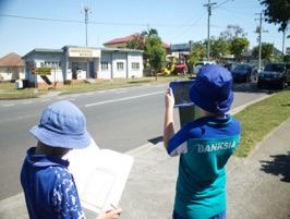 2 students working together on a suburban street studying history