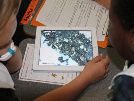 image of students looking at soil on ipad